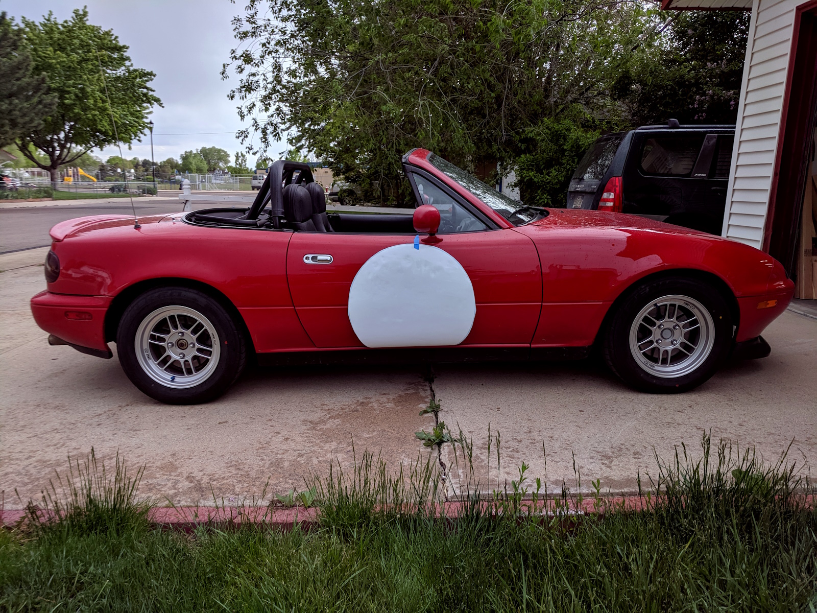 White circle on Miata car door, attached by blue tape