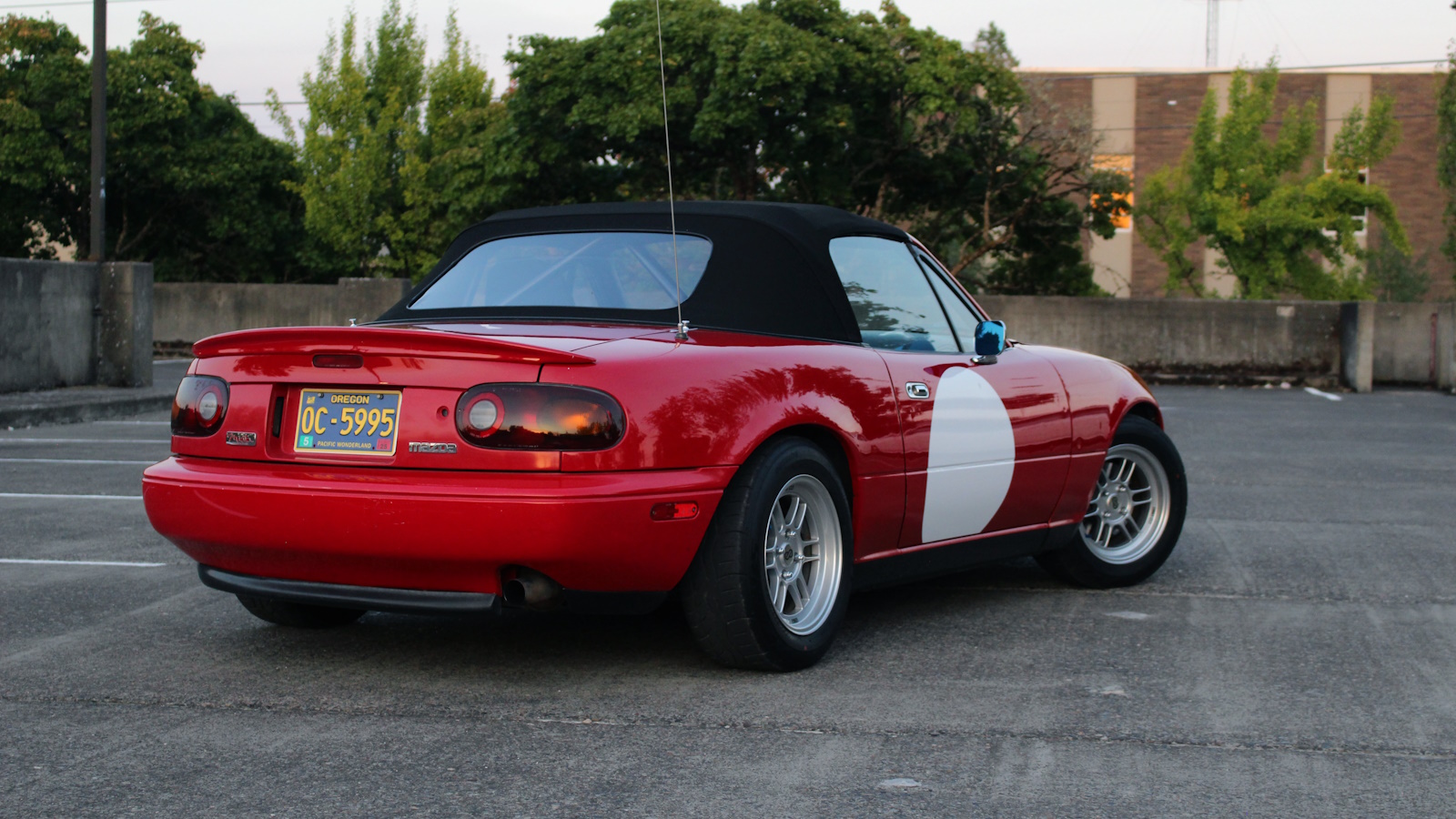 Rear quarter view of Miata with with racing circle on door
